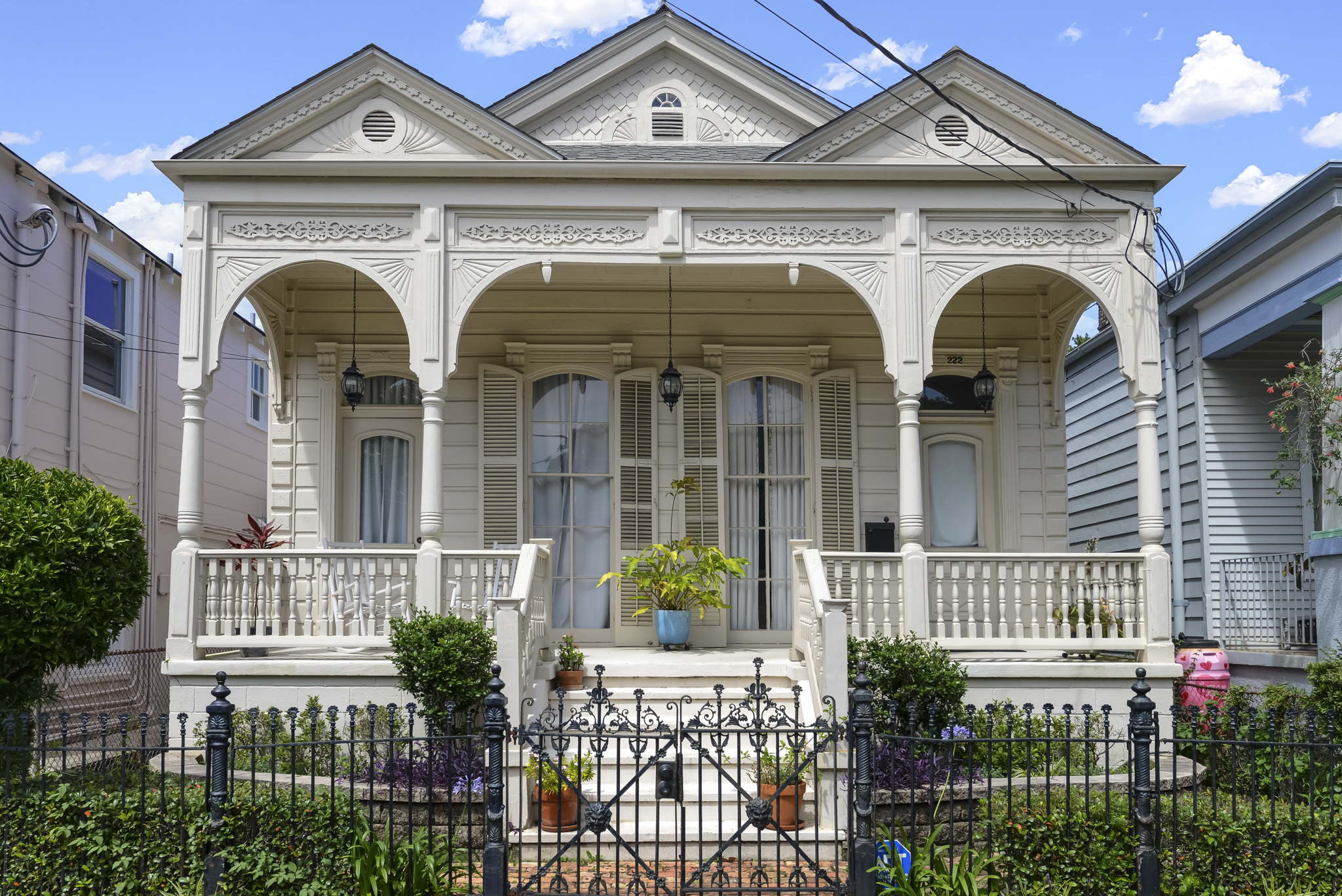 Restored Victorian cottage with ornate millwork and a deep front porch in New Orleans